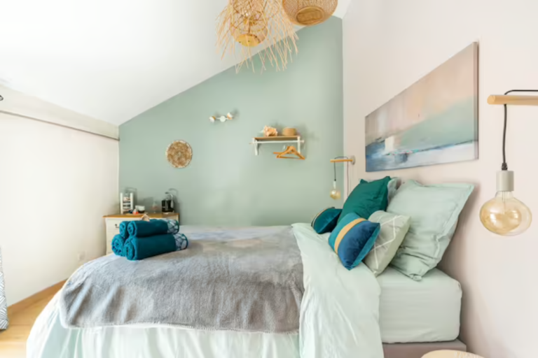 Grand lit double, ensemble bleu celadon et plaid doux gris, tableau abstrait bord de mer ton gris rose